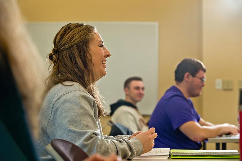 student in classroom smiling